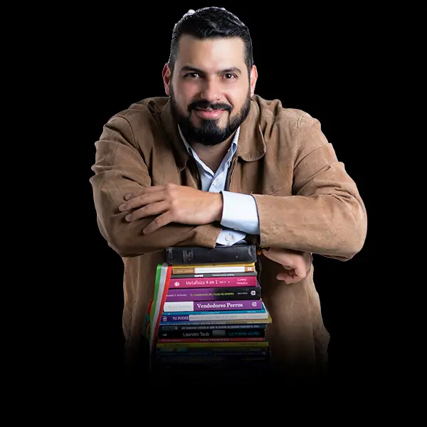 Francklin J. Silva apoyado sobre una pila de libros de negocios y desarrollo personal